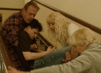 a group of people on a stairway with a man on his back