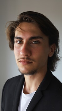 a man wearing a black jacket and white shirt